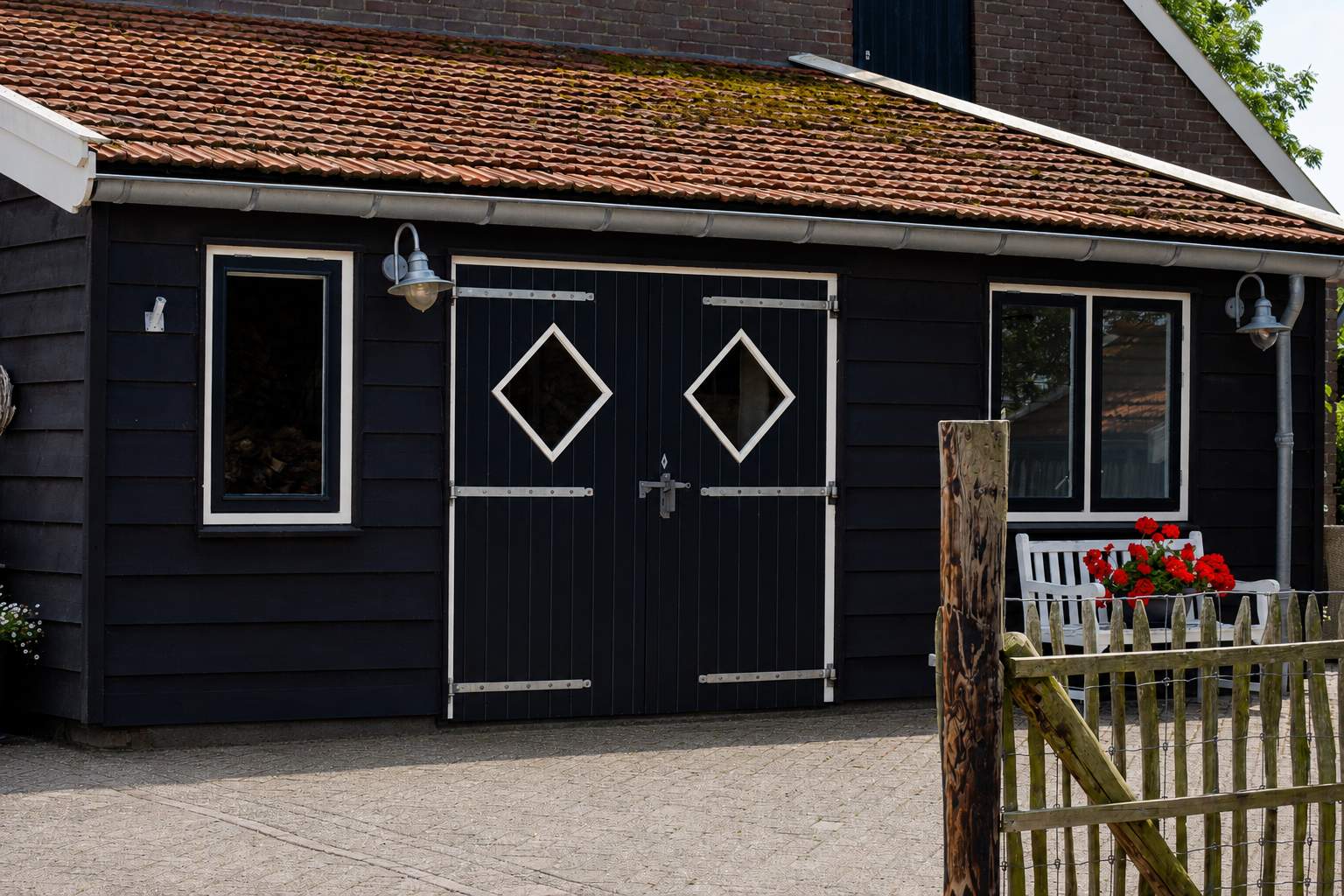 De gastenstudio van De Sluishoeve gezien vanaf het erf, met de oude schuurdeuren
